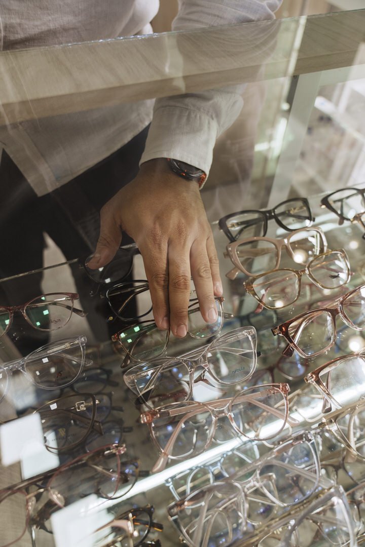 Manos eligiendo una montura sobre la vitrina